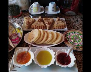 ein Tisch mit Tellern mit Gebäck und Dipsauce in der Unterkunft Dar salam in M’hamid El Ghizlane + 43 Fotos