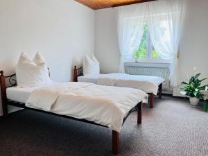 ein Schlafzimmer mit zwei Betten mit weißer Bettwäsche und einem Fenster in der Unterkunft Natascha in Fellen