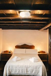 ein Schlafzimmer mit einem weißen Bett und zwei Nachttischen in der Unterkunft Casa do Botas in Sober