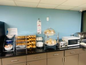 a kitchen with a counter with bread and a microwave at Days Inn by Wyndham Brooklyn Borough Park in Brooklyn