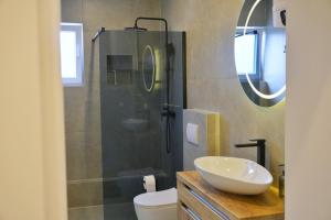a bathroom with a sink and a glass shower at Apartman Anita in Kupres +4 photos