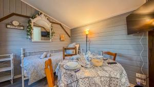 ein Esszimmer mit einem Tisch mit einer weißen Tischdecke in der Unterkunft Petit Chalet idéal à la campagne avec wifi et parking in Auguaise