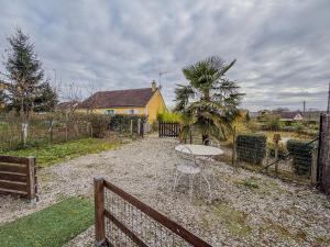 ein Tisch in einem Hof mit einem Zaun in der Unterkunft Petit Chalet idéal à la campagne avec wifi et parking in Auguaise
