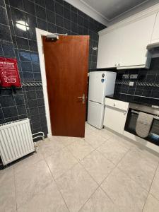 a kitchen with a brown door and a refrigerator at Vacant Nests Ivy Cottage 3BR Wi-Fi in Banton +2 photos