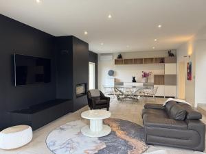 a living room with a couch and a table at Villa Belvédère - Jacuzzi, Billard, Garage & Vue in Le Mans