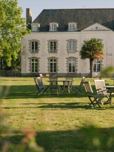 a group of chairs and a table in front of a building at Domaine de Kermadio in Pluneret