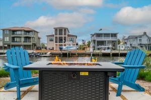 a table with two blue chairs and a fire pit at Oyster House Waterfront 3b2b Kayaks BBQ Games in Hernando Beach