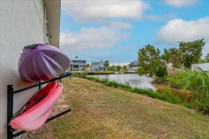 a pink kayak on the side of a building next to a river at Oyster House Waterfront 3b2b Kayaks BBQ Games in Hernando Beach