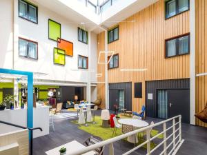 widok na budynek ze stołami i krzesłami w obiekcie Ibis Styles Toulouse Labège w mieście Labège