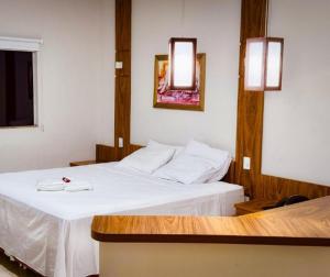a hotel room with two beds and a mirror at Monte Castro Executive Hotel in Araguari