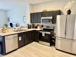 a kitchen with black cabinets and stainless steel appliances at Windsor Hill Resort Minute to Disney & Theme Parks in Orlando