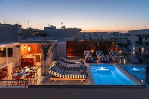a balcony with chairs and a swimming pool on a building at Nissos Home by Prime Stay in Hersonissos