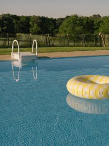 a swimming pool with a chair and a raft in the water at Domaine de Kermadio in Pluneret +43 photos