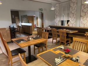 a dining room with wooden tables and chairs at Krug zum Schlaubetal in Mixdorf