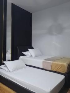 two beds sitting next to each other in a room at DHome Laksamana Melaka in Malacca +16 photos