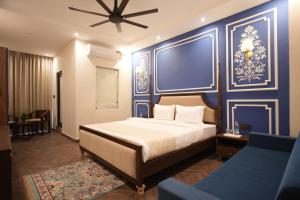 a bedroom with a bed and a blue wall at Rambagh Resort by Stotrak, Gwalior in Gwalior +127 photos