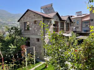a stone house on a hill with a garden at Guest House Anahit Ijevan in Ijevan