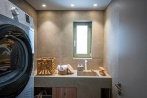 Villa Alquimia Bb with private Swimming pool في Limín Khersonísou: حمام مع مغسلة وغسالة ملابس