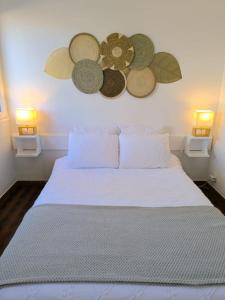 a bedroom with a white bed with two lights on it at VK Lake in Aureilhan