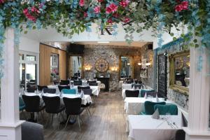 a restaurant with white tables and chairs and flowers at Townsend House Guest House in Birr
