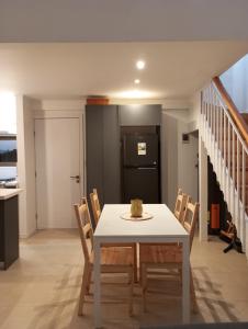 uma sala de jantar com uma mesa e cadeiras brancas em Oceana Suites en Algarrobo em San Antonio