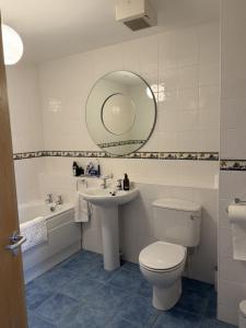 ein Badezimmer mit Toilette, Waschbecken und Spiegel in der Unterkunft John's Seafront Apartment - B5 in Newcastle