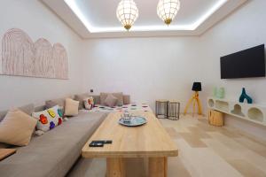 ein Wohnzimmer mit Sofa und Tisch in der Unterkunft Luxury Central Apartment Marrakech Pool Near train station in Marrakesch
