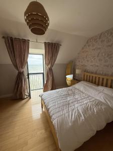 ein Schlafzimmer mit einem Bett und einem großen Fenster in der Unterkunft John's Seafront Apartment - B5 in Newcastle