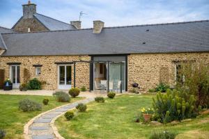 a brick house with a garden in front of it at Huna lulu in Pleslin-Trigavou