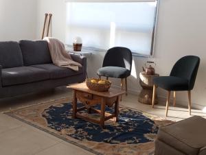 uma sala de estar com um sofá e duas cadeiras em Oceana Suites en Algarrobo em San Antonio