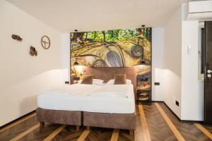 Un dormitorio con una cama con un mural en la pared. en Boutique Suites by K A M E L U, en Gengenbach