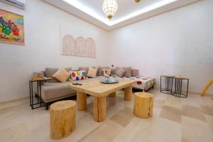 ein Wohnzimmer mit Tisch und Couch in der Unterkunft Luxury Central Apartment Marrakech Pool Near train station in Marrakesch