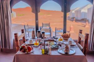 a table with food on it with a view of a desert at Luxury Camp Sahara in Merzouga