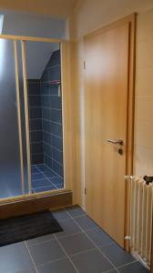 a bathroom with a door and a tile floor at Casa Anna in Osogna