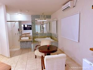 a living room with a table and a bathroom at Monte Castro Executive Hotel in Araguari