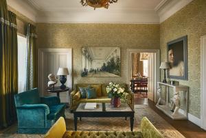 a living room with a couch and a table at Rocco Forte Hotel De La Ville in Rome