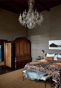 a bedroom with a bed and a chandelier at Ballotina, Tulbagh Cape Wineland in Tulbagh