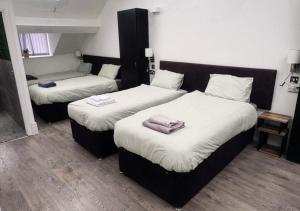 een kamer met twee bedden met handdoeken erop bij Williamson Suites - Apartment 2 in Liverpool