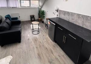 een woonkamer met een zwart aanrecht en een bank bij Williamson Suites - Apartment 2 in Liverpool