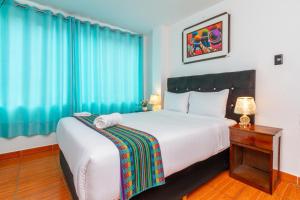 ein Schlafzimmer mit einem großen weißen Bett mit blauen Vorhängen in der Unterkunft Inkary Hotel Machupicchu in Machu Picchu + 82 Fotos