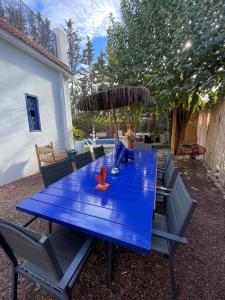 Una mesa de picnic azul con sombrilla y sillas. en La kasbah bleue, en Marrakech
