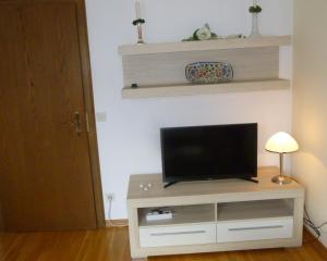 een flatscreen-tv zittend op een tv-standaard bij Ferienwohnung Edmeier in Bernau am Chiemsee