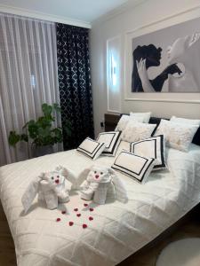two stuffed elephants sitting on top of a bed at Apartament Anna De Lux z tarasem Zamość-Roztocze in Zamość