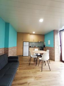 een woonkamer met een bank, een tafel en stoelen bij Studio Casa Miradouro Fafião in Fafião