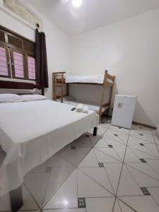 1 Schlafzimmer mit 2 Betten und Fliesenboden in der Unterkunft Hotel Silveira in Guarapari + 6 Fotos