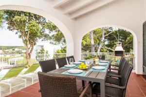 Un comedor al aire libre con mesa y sillas. en Villa Casa de Olives, en Cala Galdana