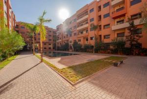 ein Innenhof in einem Wohngebäude mit Pool in der Unterkunft Luxury Central Apartment Marrakech Pool Near train station in Marrakesch