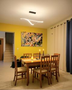 een eetkamer met een tafel en stoelen en een schilderij bij Aegean Helios Houses in Gennadi