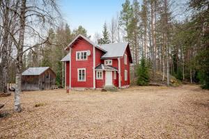 a red house in the middle of a forest at Beautiful detached house in Sörsjön
