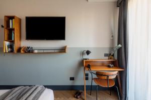 a bedroom with a desk and a tv on the wall at c-hotels Club House Roma in Rome